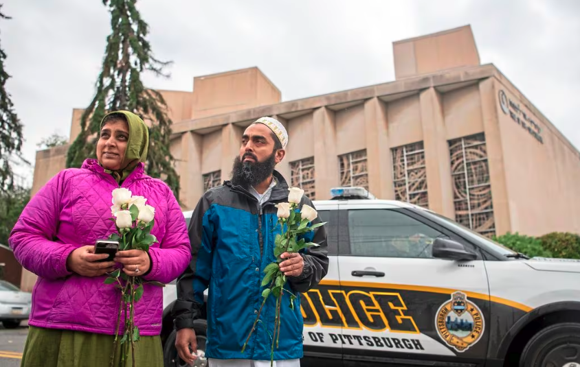 (Alexandra Wimley | Pittsburgh Post-Gazette | The Associated Press) Samina Mohamedali, left, and her husband, Kutub Ganiwalla, members of the Dawoodi Bohra Muslim community, both of North Hills, prepare to place flowers on a memorial in front of the Tree of Life Congregation, Sunday, Oct. 28, 2018, in Squirrel Hill neighborhood of Pittsburgh.